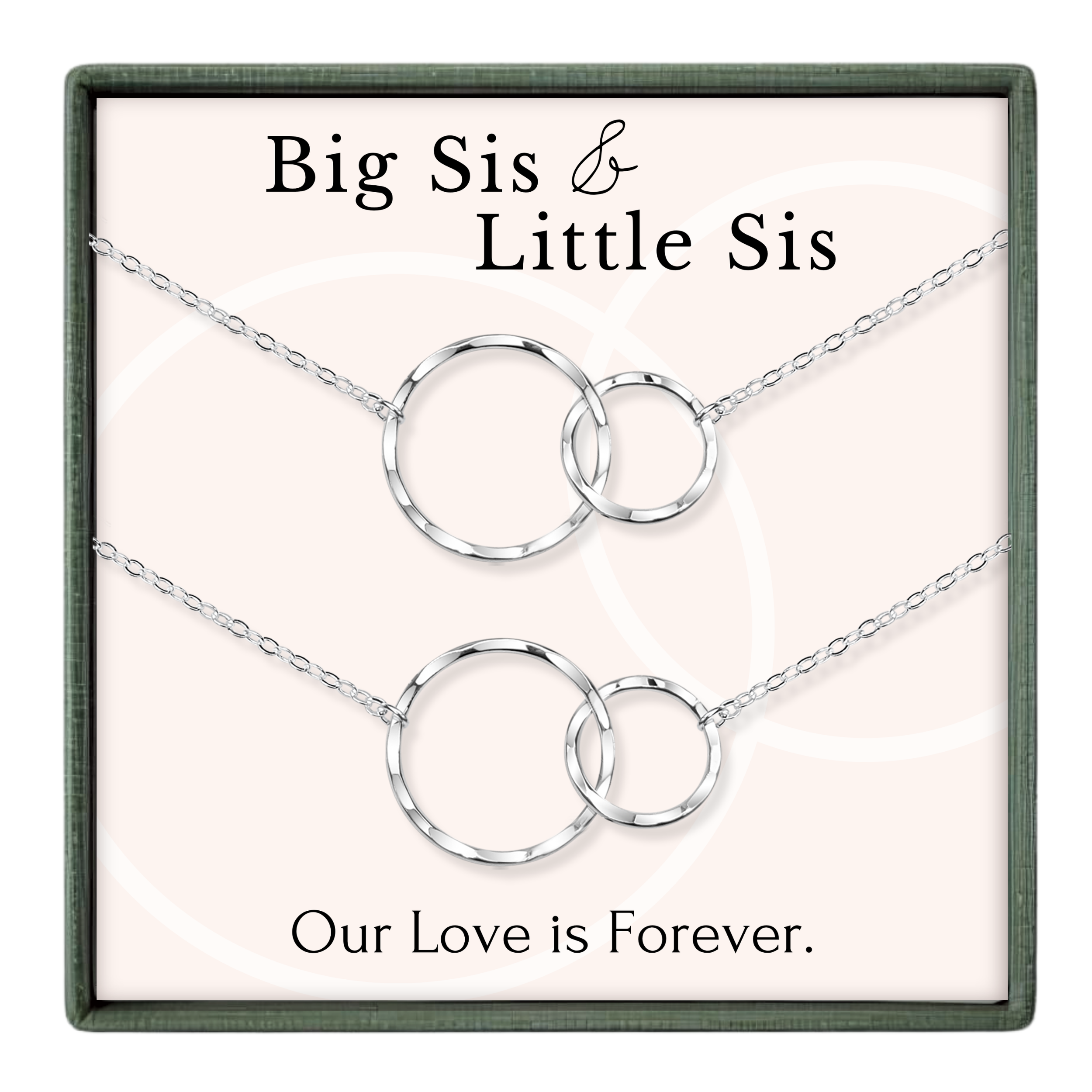 a set of two silver necklaces with interlocking circular pendants, accompanied by the text "Big Sis & Little Sis" and "Our Love is Forever."