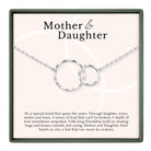 a necklace with two interlocking silver rings, accompanied by a caption describing the necklace as a special bond that spans the years, symbolizing trust, love, and friendship between a mother and daughter.