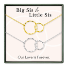 The image is a jewelry box containing two necklaces with interlocking circular pendants, labeled as "Big Sister & Little Sister" and "Our Love is Forever."