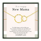 a necklace with two gold-colored rings, accompanied by a heartfelt message about the joys and challenges of motherhood.