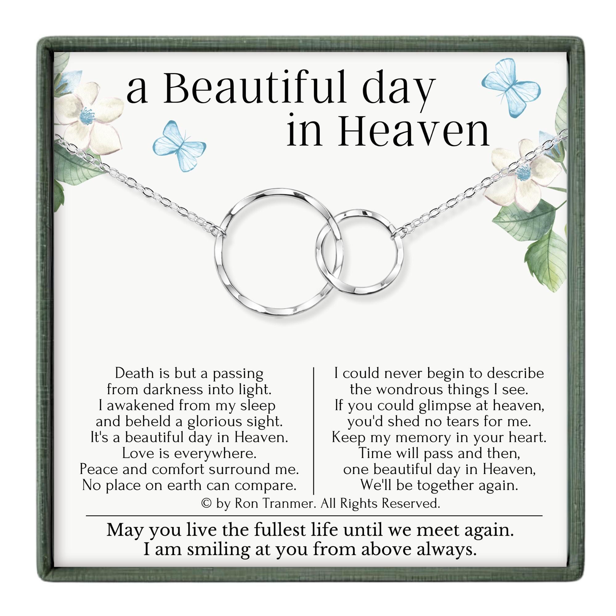 A pendant necklace with a quote about finding beauty in the midst of darkness, accompanied by a floral design.