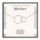 The image is a memorial box for a mother, featuring a silver necklace with two interlocking rings and a heartfelt message that reads "In memory of your beautiful Mother. She lived and laughed and loved."