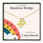 The image is a necklace with a charm that says "I crossed the Rainbow Bridge" and a paw print charm, accompanied by the text "knowing that I was loved."