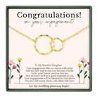 The image is a gift box containing a necklace with two gold rings and a heartfelt message about an engagement.