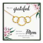 The image is a necklace with three interlocking rings, accompanied by a heartfelt message about a mother.