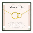 a necklace with two gold rings, accompanied by a message that reads "To an amazing Mama to be".