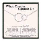 The image is a necklace with a pendant that says "What Cancer Cannot Do". The necklace is described as a "reminder that you are never alone".