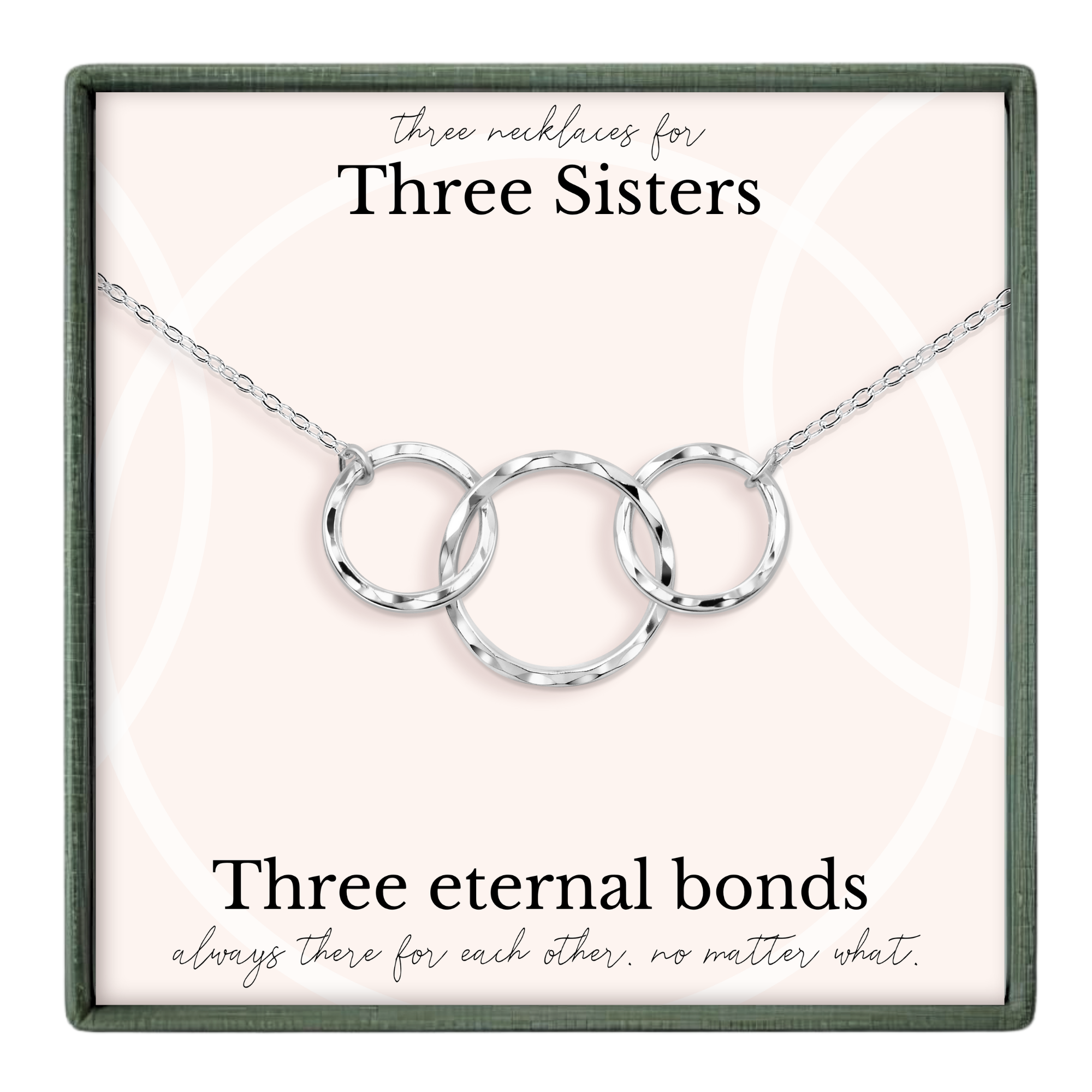 a necklace with three circular rings, each ring connected to the other, forming a chain. The necklace is presented in a box with a label that reads "Three necklaces for Three Sisters".