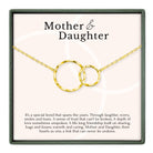 a necklace with two interlocking gold rings, accompanied by a caption describing the necklace as a special bond that spans the years, symbolizing trust, love, and friendship between a mother and daughter.