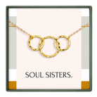 A necklace with three gold rings, each ring connected to the other, forming a circular design. The necklace is displayed in a box with the text "SOUL SISTERS."