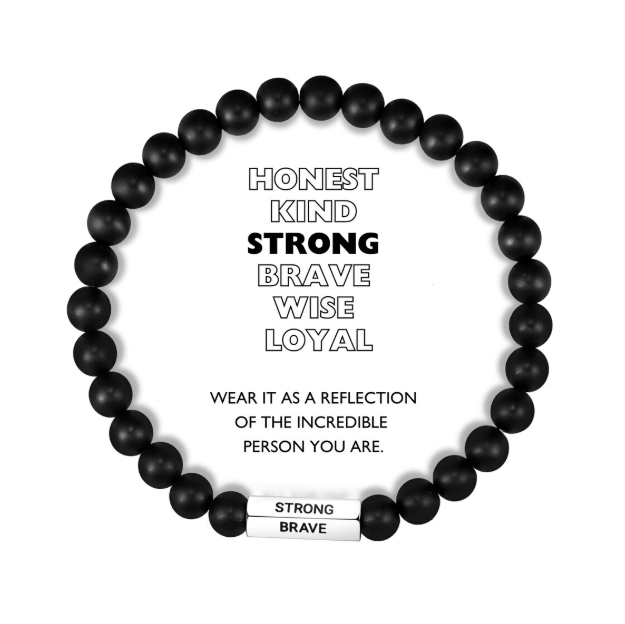 A beaded bracelet with brown and black beads, and a stainless steel pipe with the words 'HONEST', 'KIND', 'STRONG', 'BRAVE', 'WISE', 'LOYAL' engraved. The bracelet is described as a reflection of the incredible person the wearer is.