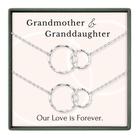 a set of silver necklaces with interlocking circular links, accompanied by the text "Grandmother & Granddaughter" and "Our Love is Forever."