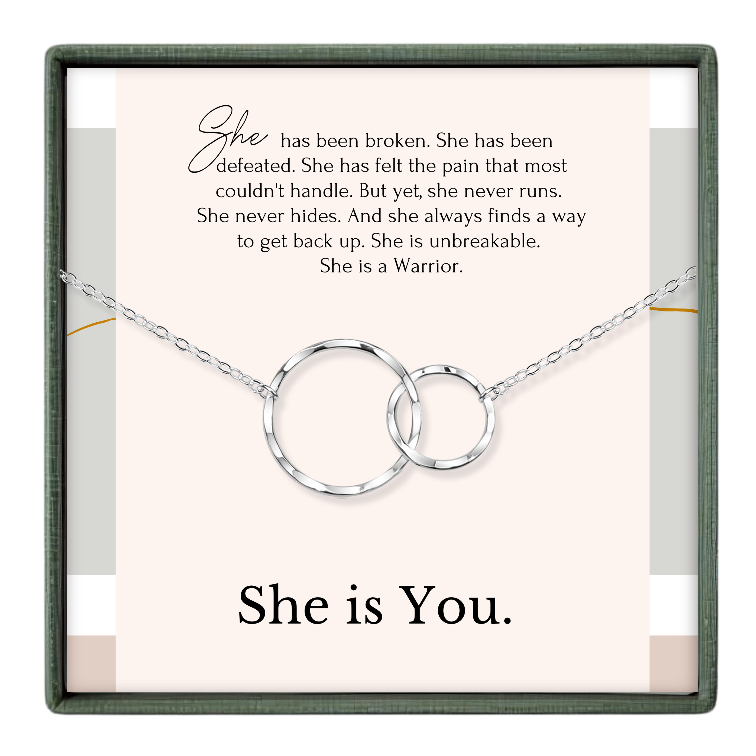 The image is a necklace with two interlocking rings, accompanied by a motivational message about a woman who has overcome pain and is now a warrior.