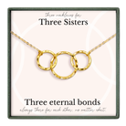 a necklace with three circular links, each link connected to the other, forming a chain. The necklace is presented in a box with a label that reads "Three necklaces for Three Sisters".