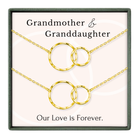 a set of two gold-colored necklaces with interlocking circular links, accompanied by the text "Grandmother & Granddaughter" and "Our Love is Forever."